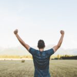 japheth-mast-Ls3yexjyRpk-unsplash Mann welcher die Fäuste siegreich in die Höhe streckt